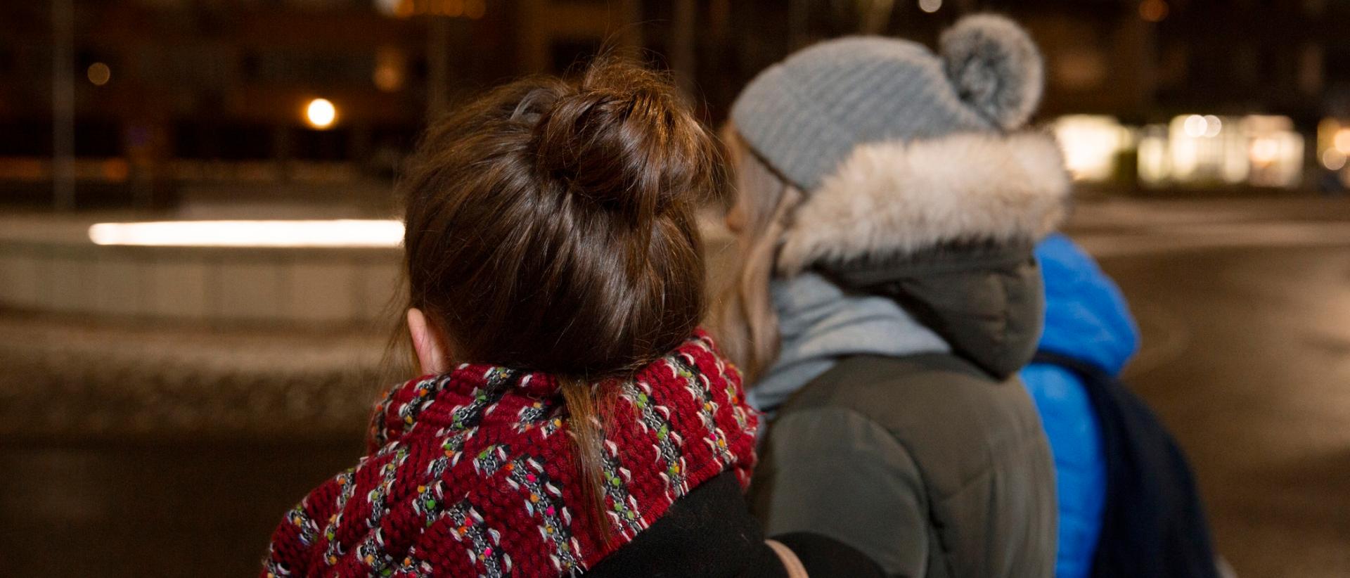 Kaksi teinitytt&ouml;&auml; selin ulkona talvih&auml;m&auml;r&auml;ss&auml;