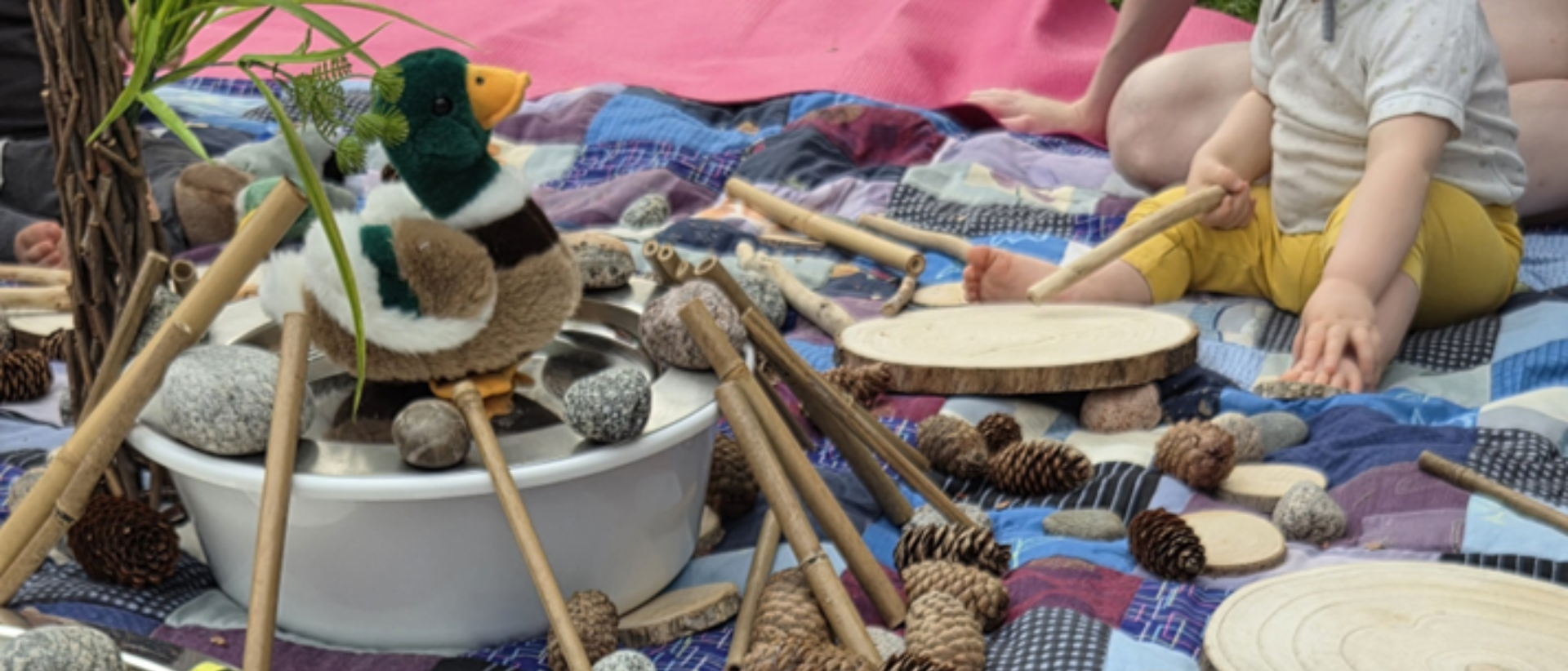 Viltillä vauvan jalat käpyjä, keppejä ja pehmosorva pesuvadissa