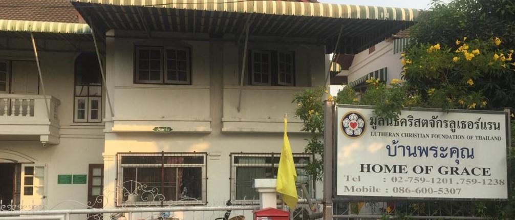 kuva avustuskohteesta Thaimassa. Kuvassa talo ja sen edustalla kyltti jossa lukee Armon koti englanniksi.