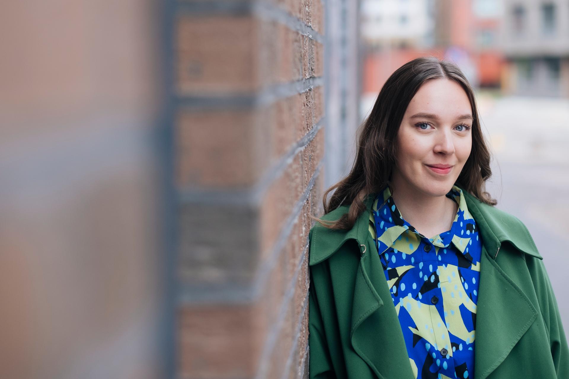 Nainen katsoo kameraan.