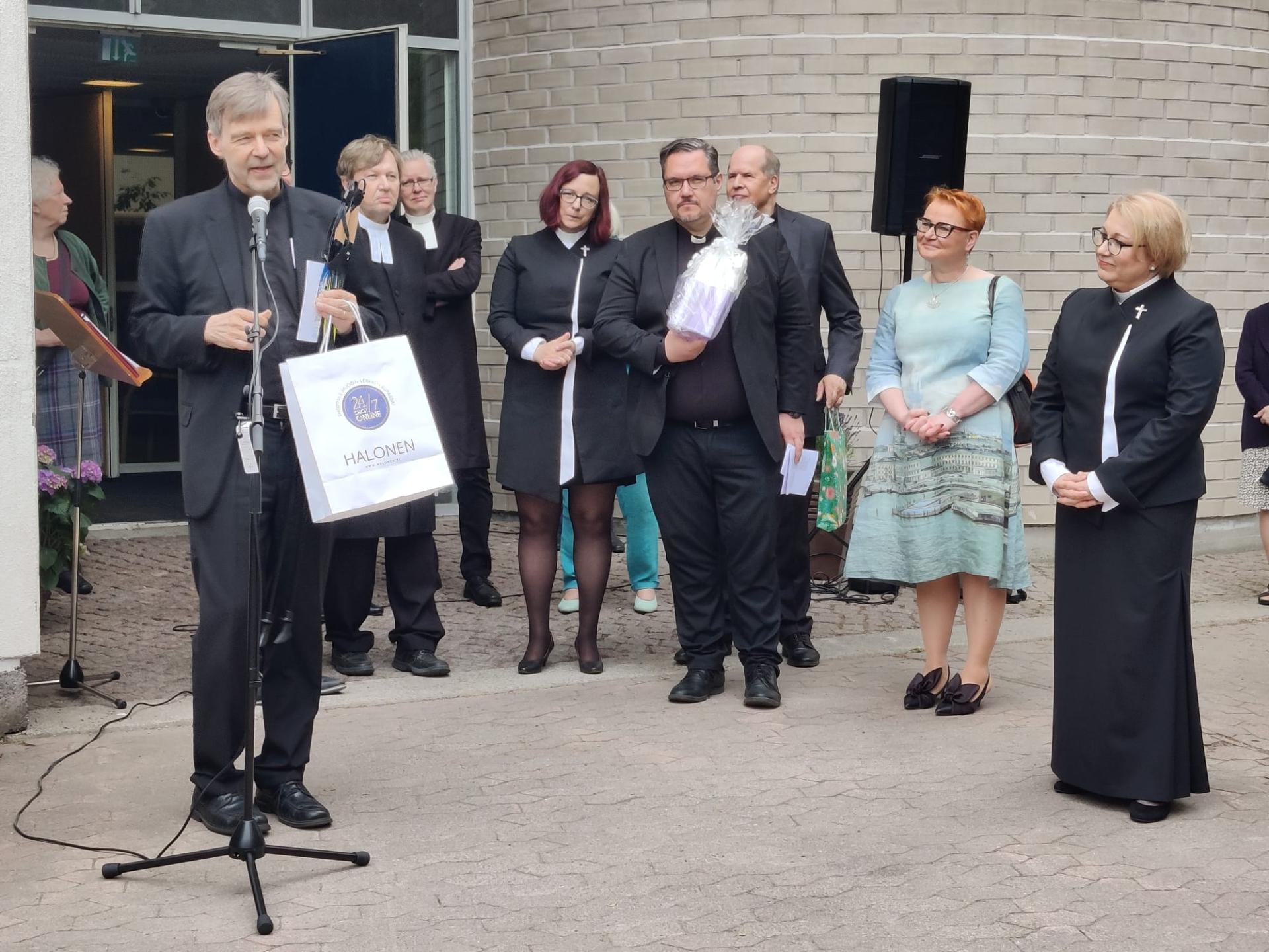 Timo Pekka Kaskinen puhuu Minnamari Helasepälle virkaanasettajaisissa. Kuvassa näkyy seurakuntayhtymän johtajia