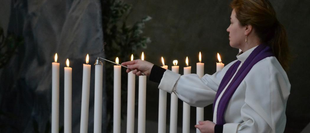 Pappi Virpi Koskinen sammuttaa opetuslasten kynttilöitä Kannelmäen kirkossa kiirastorstai-iltana