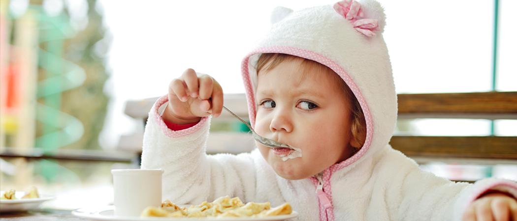 Veikeä pieni lapsi syö muroja.