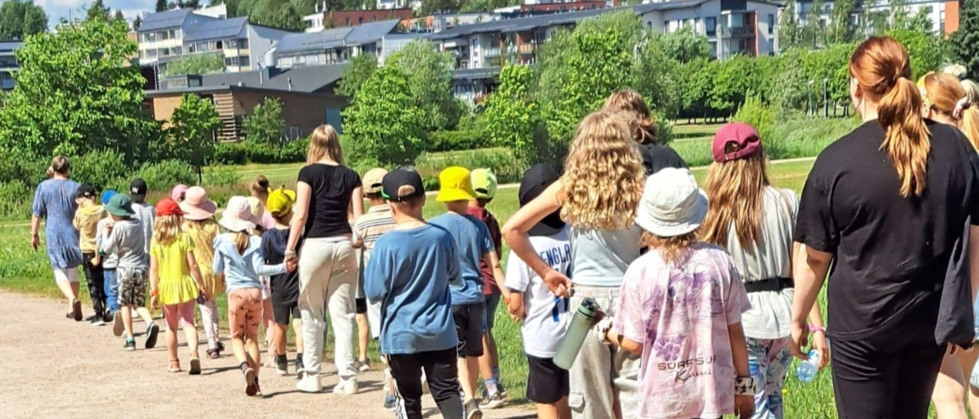 Koululaisia k&auml;velem&auml;ss&auml; ohjaajien kanssa kes&auml;isess&auml; Viikiss&auml;