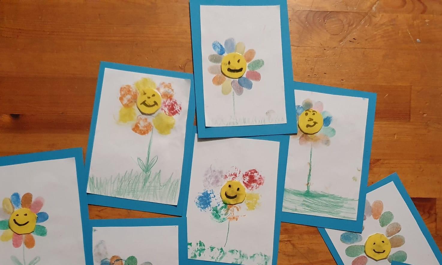askarreltuja kortteja, joissa värikkäitä kukkia hymynaamat keskellä