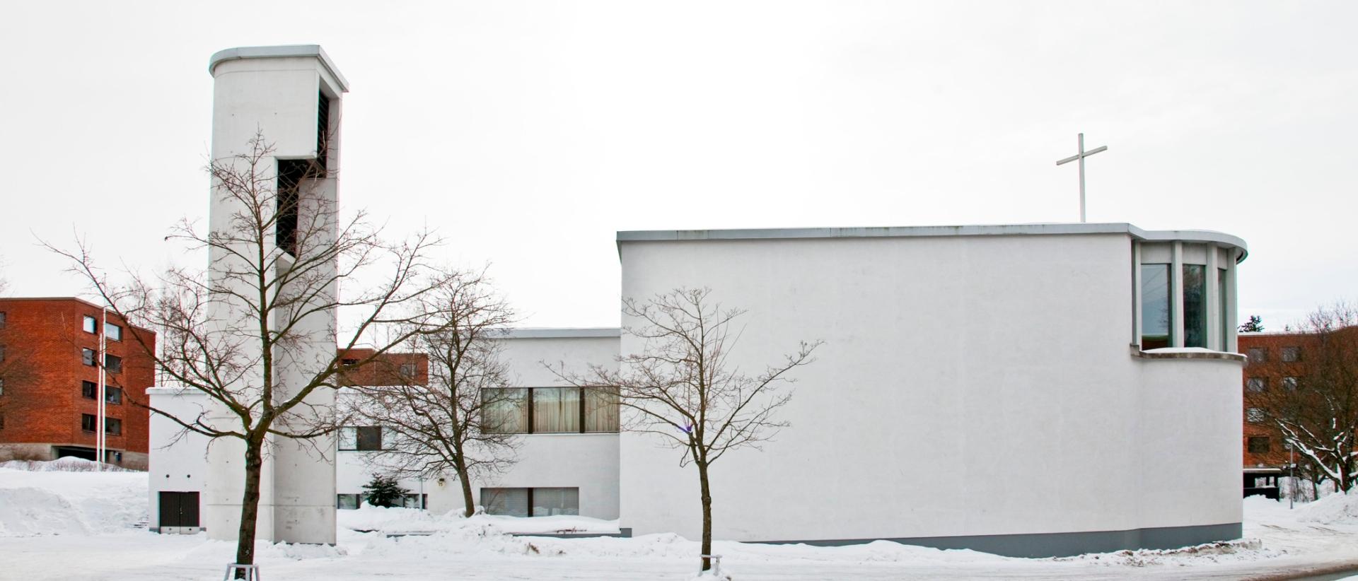 Valkoinen funkkistyylinen kirkko talvimaisemassa