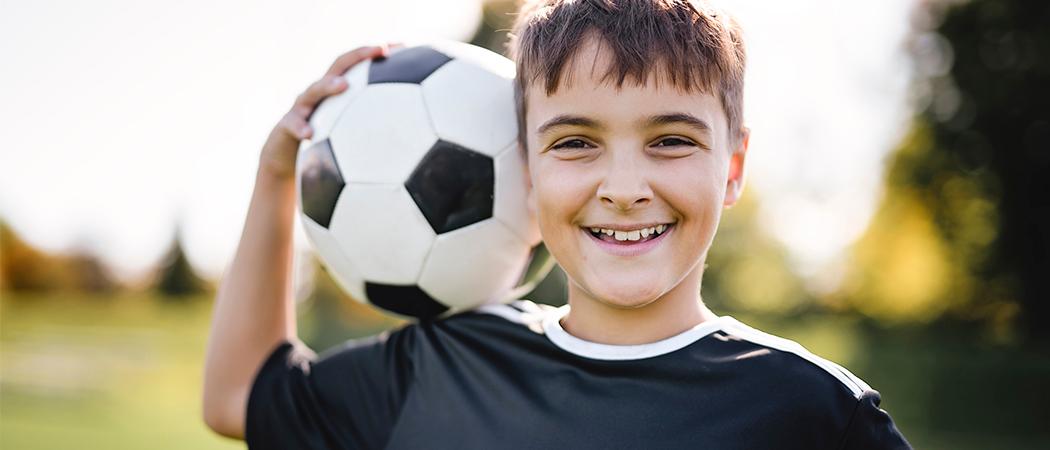 poika jalkapallon kanssa