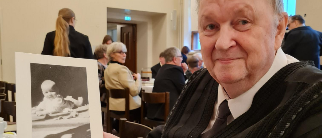 80-vuotias Kalervo Korjus Kallion seurakunnan syntymäpäiväkahveilla. Kädessään hänellä on kuva itsestään lapsena.