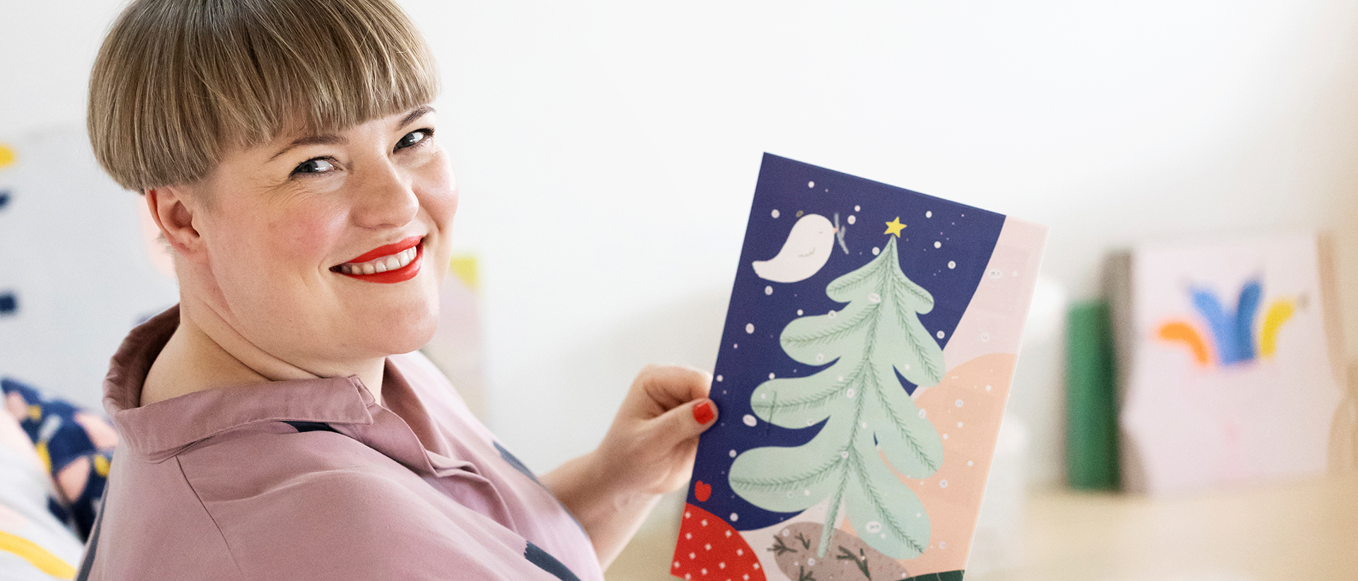 Porträtt av illustratören Hanna-Riikka Heikkilä som håller församlingarnas julkalender.