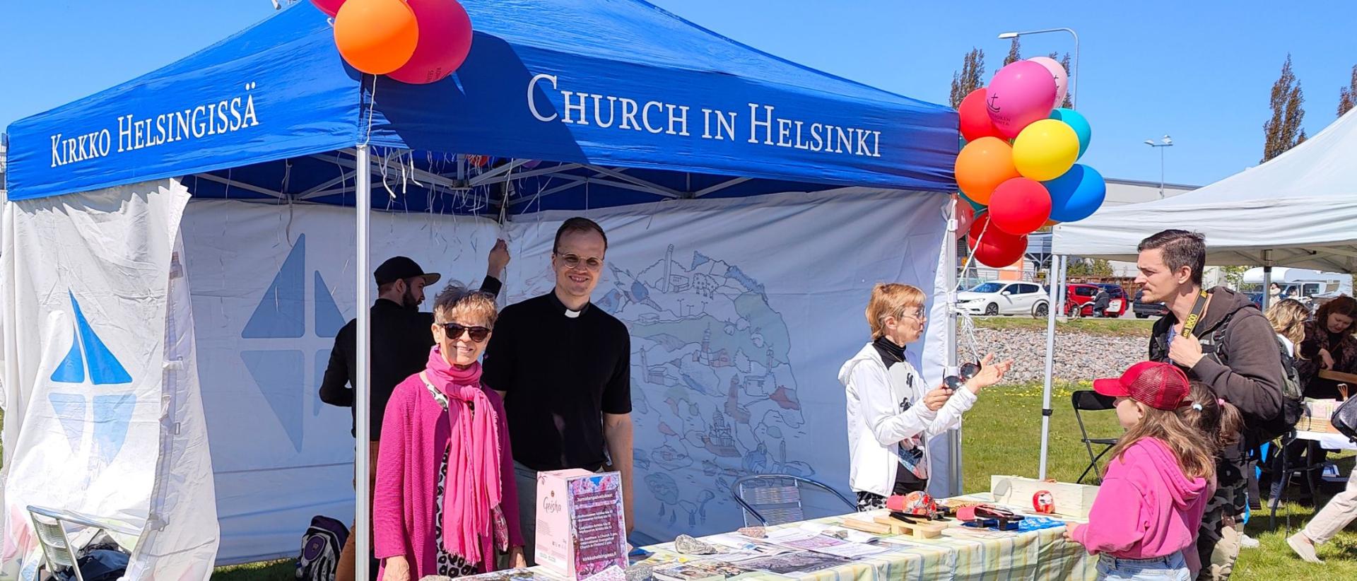 Kirkko Helsingissä-teltta ilmapalloineen Hanami-juhlassa Roihuvuoren kirsikkapuistossa 2023. Päivystämässä Roihuvuoren srk työntekijöitä