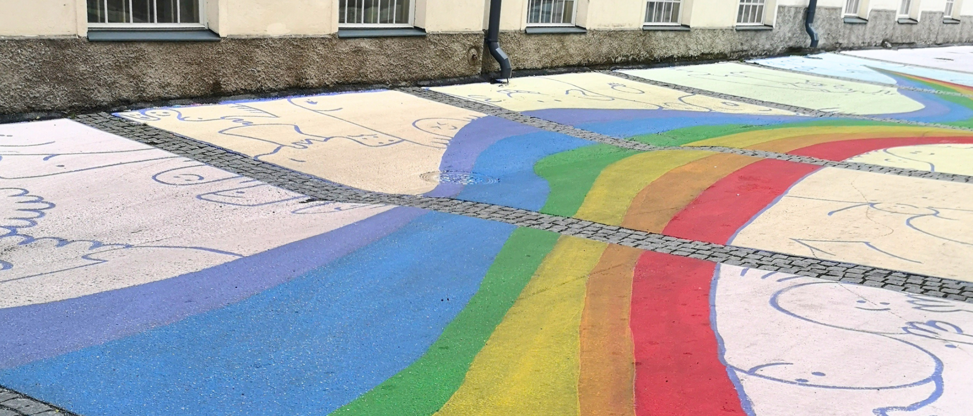 Kadulle tai pihalle maalattu värikäs sateenkaarikuvio