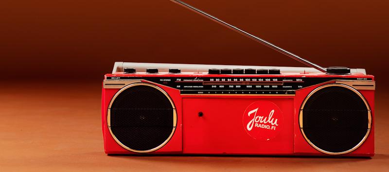 Kuvassa punainen radio, jonka kyljessä Jouluradio-tarra