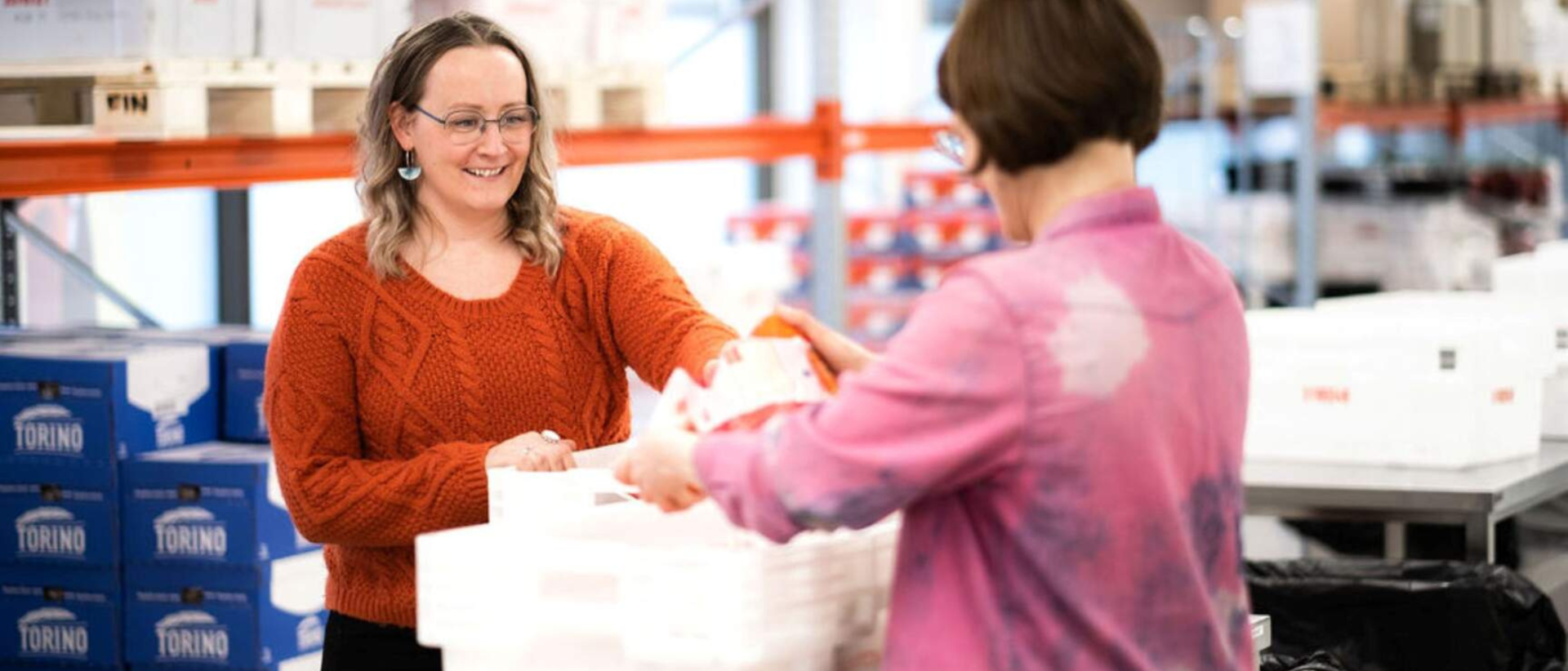 Kaksi naista tutkii valkoista, p&ouml;yd&auml;ll&auml; olevaa muovilaatikkoa