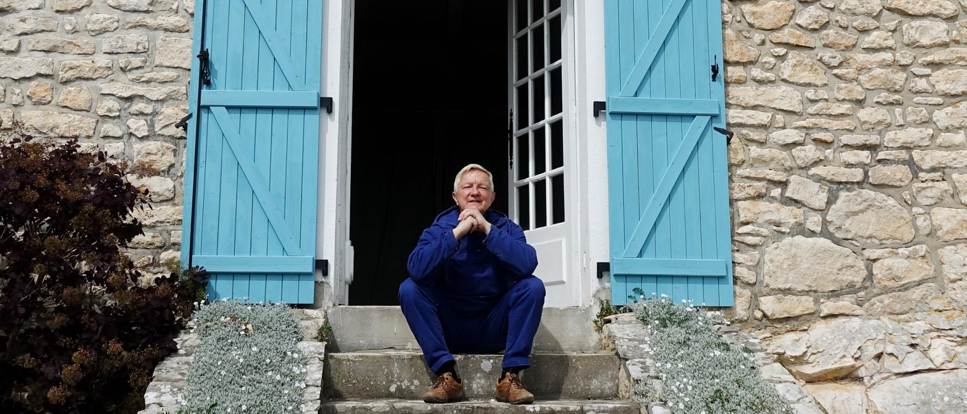 Hannu Väisänen istumassa Ranskan-talonsa portailla