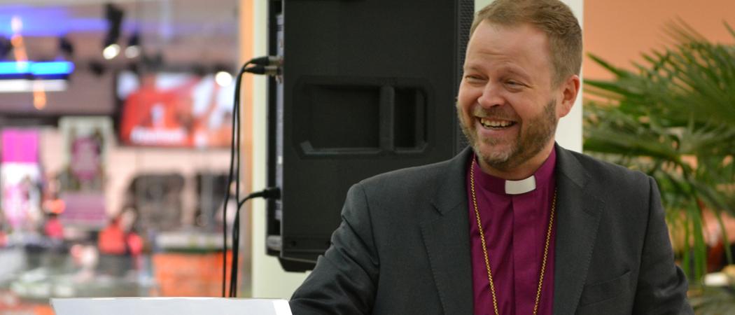 Piispa Teemu Laajasalo nauraa Kauppakeskus Kaaressa järjestetyssä Aamukahvit piispan kanssa -tilaisuudessa.