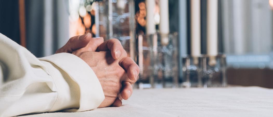 K&auml;det ristittyn&auml; alttarilla.