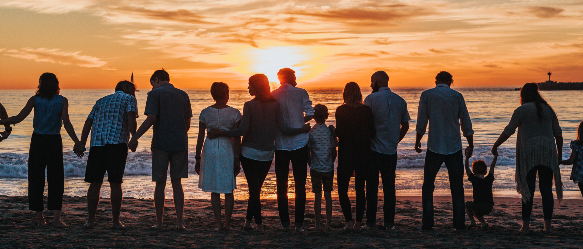Perheitä rannalla, siluetti, auringonlasku.