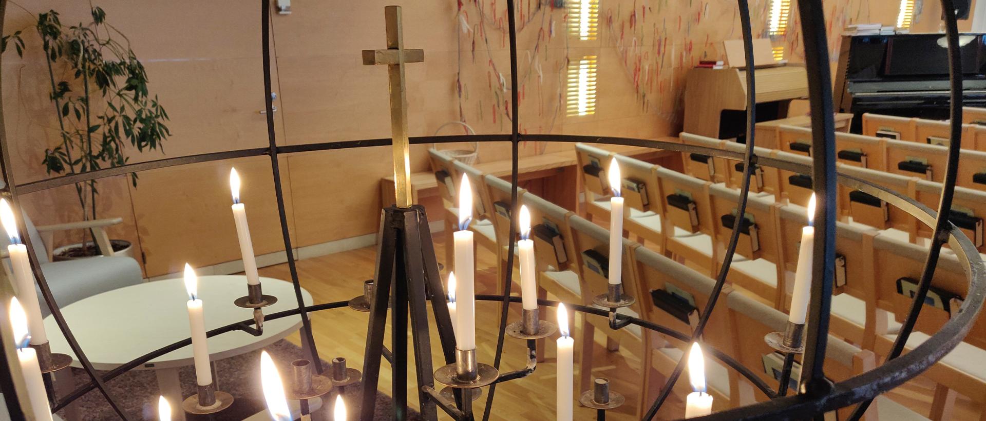 Vartiokylän kirkon lähetyskynttelikkö, jossa palavia kynttilöitä