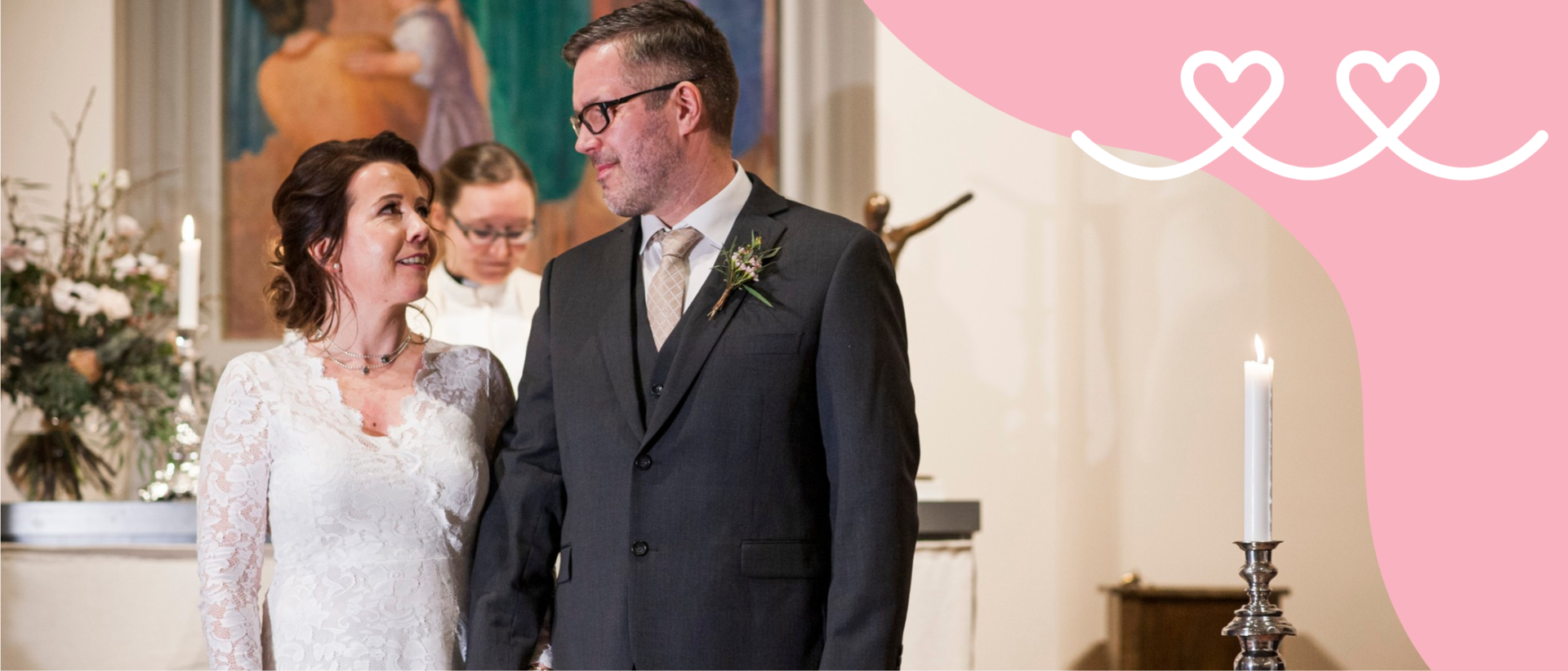 Nainen, jolla valkoinen h&auml;&auml;puku, ja mies tummassa puvussa seisovat alttarin edess&auml; toisiaan katsoen. Taustalla vihkipappi.