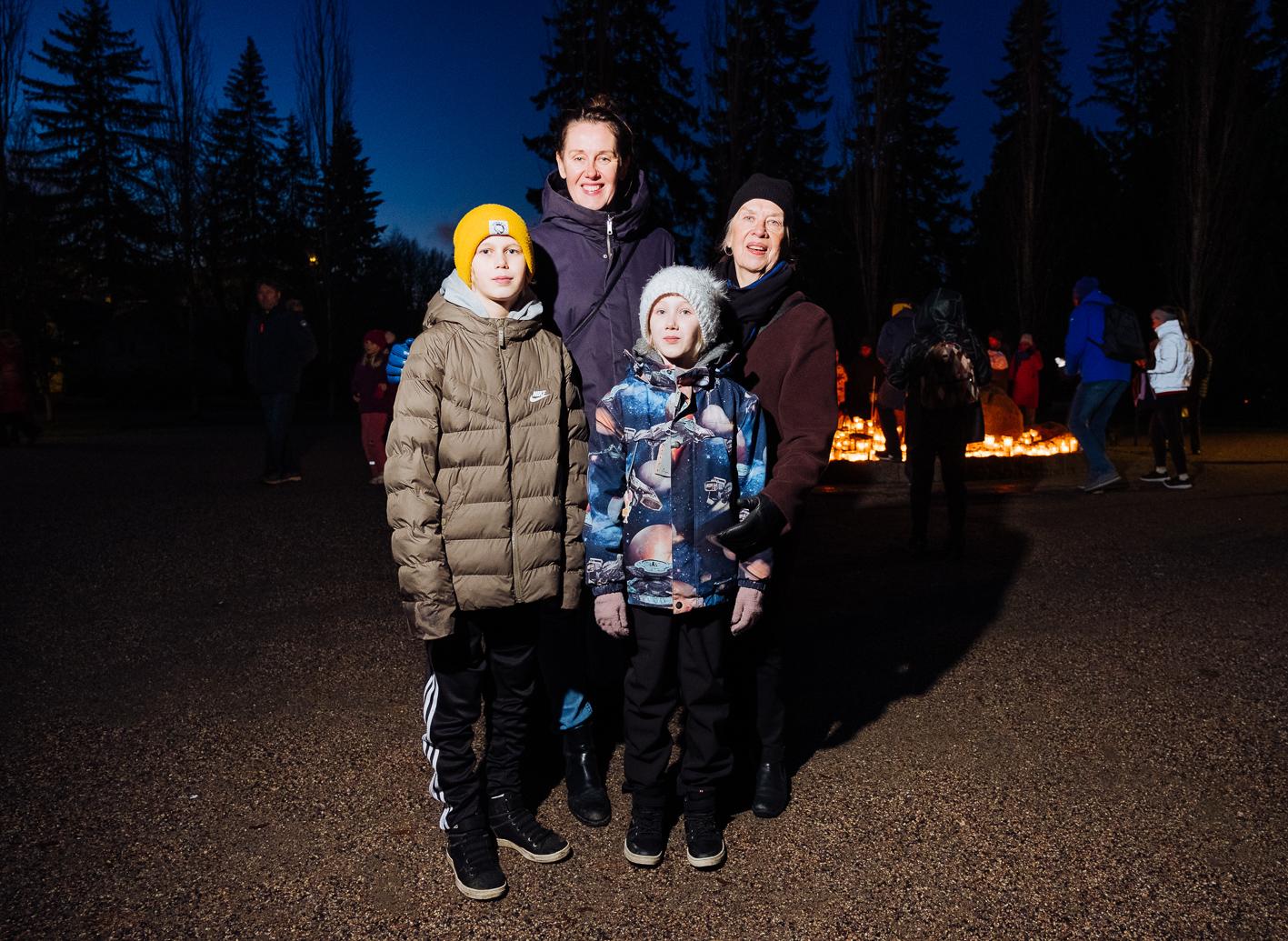 Perhe hymyilevänä Malmin hautausmaalla pyhäinpäivänä