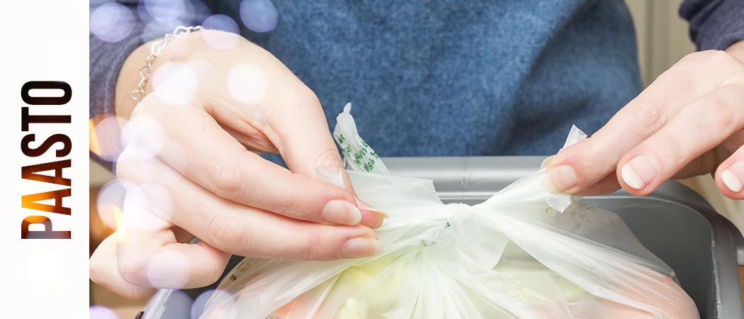 Lähikuva biojätepussista, jota henkilö solmii kiinni.