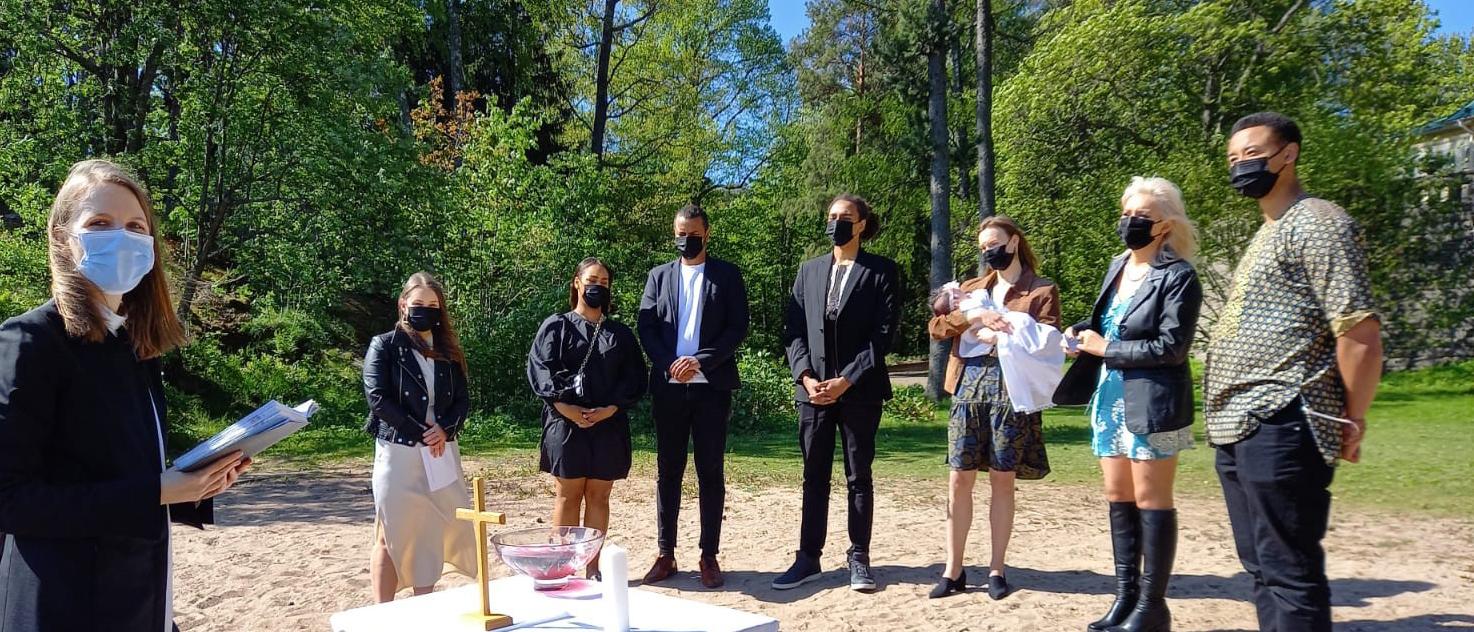 Kastetilaisuus Laajarannassa meren rannalla. Kuvassa pappi Essi Lyytinen, kastettava vauva ja lähipiiri.