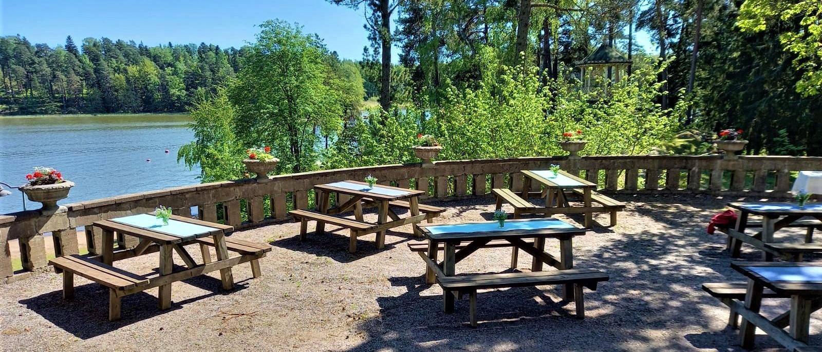 Laajarannan terassi. Näkymä merelle, pöydissä liinat ja kukat.