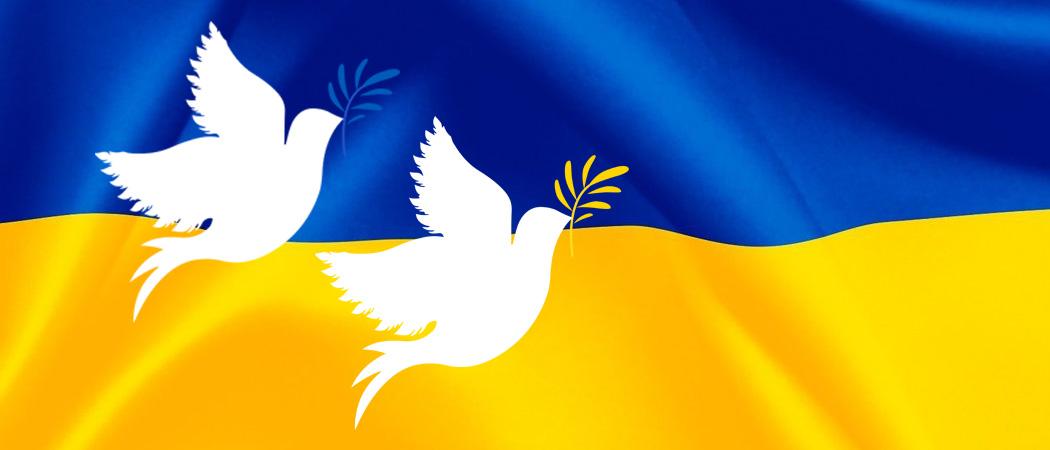 Ukrainan sinikeltaisen lipun päällä kaksi valkoista piirrettyä rauhankyyhkyä sininen ja keltainen oksa nokassaan.