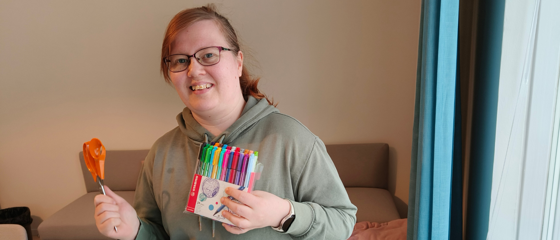 Varhaisnuorisotyöntekijä Anne Ketola kädessään sakset ja tusseja