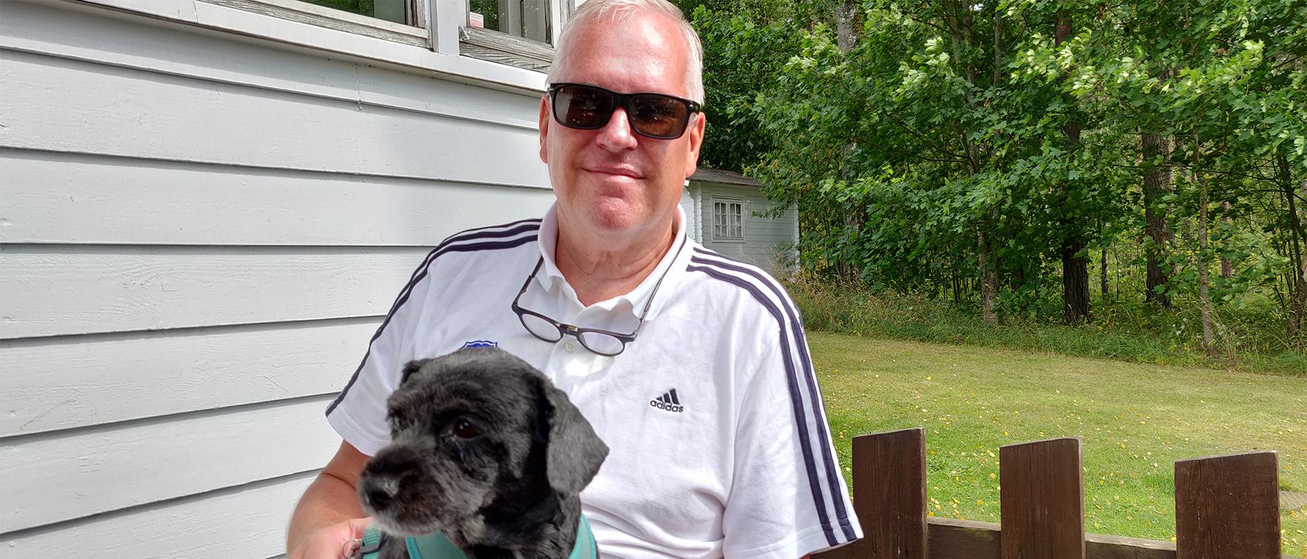 Veijo Kekkonen Elle-koiransa kanssa kuvattuna Stansvikin kartanon terassilla aurinkolasit päässä