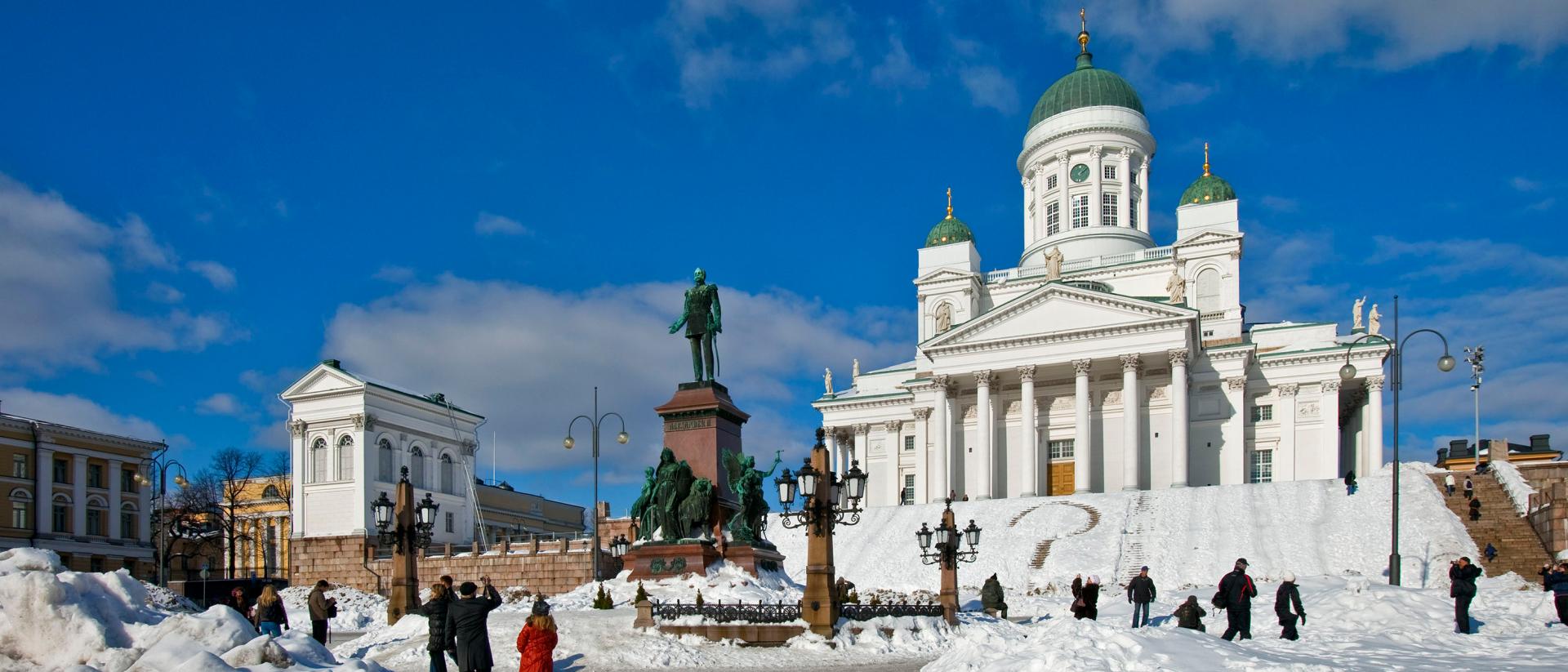 Helsingin tuomiokirkko talvella, kinosten keskellä ihmiset seisoskelevat Senaatintorilla