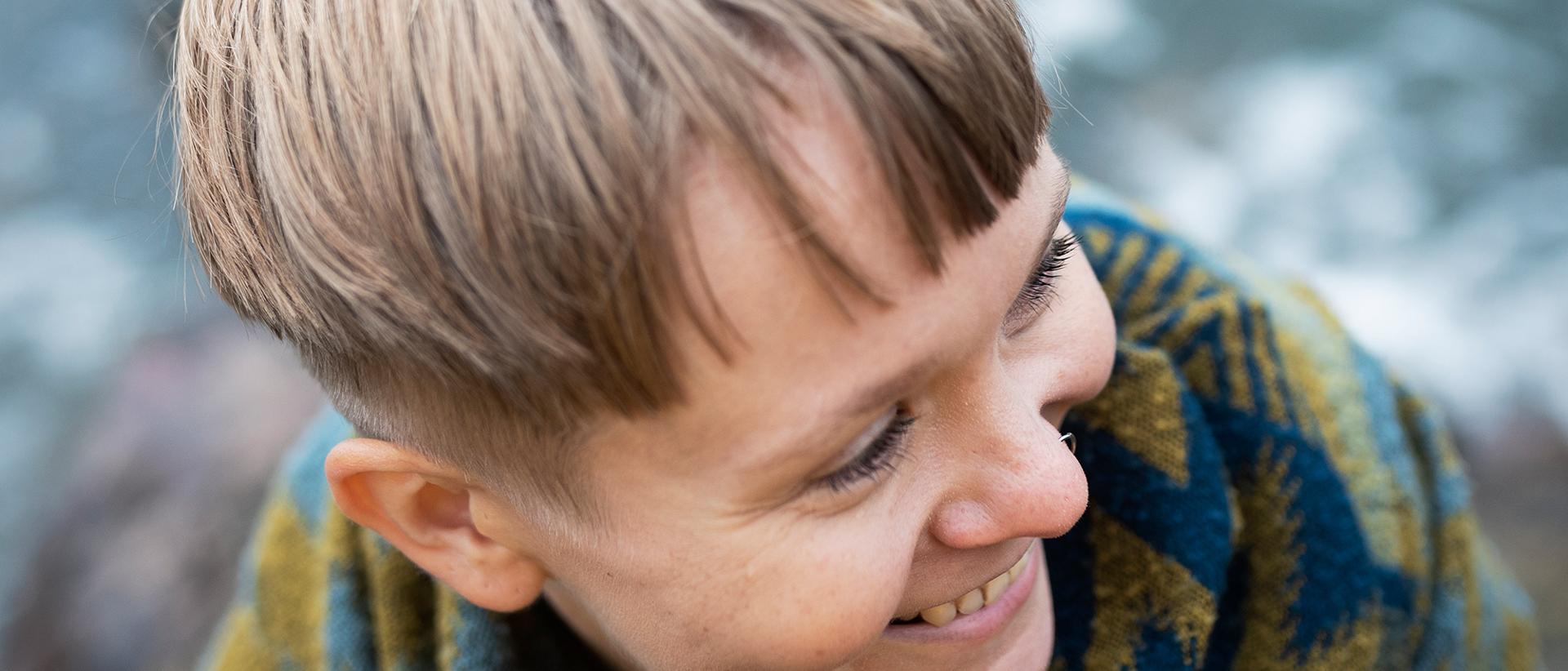 Tiukasti rajattu lähikuva hymyilevästä Hanna Raatikaisesta, jonka katse kohdistuu oikealle alaviistoon. Kuva: Johanna Erjonsalo