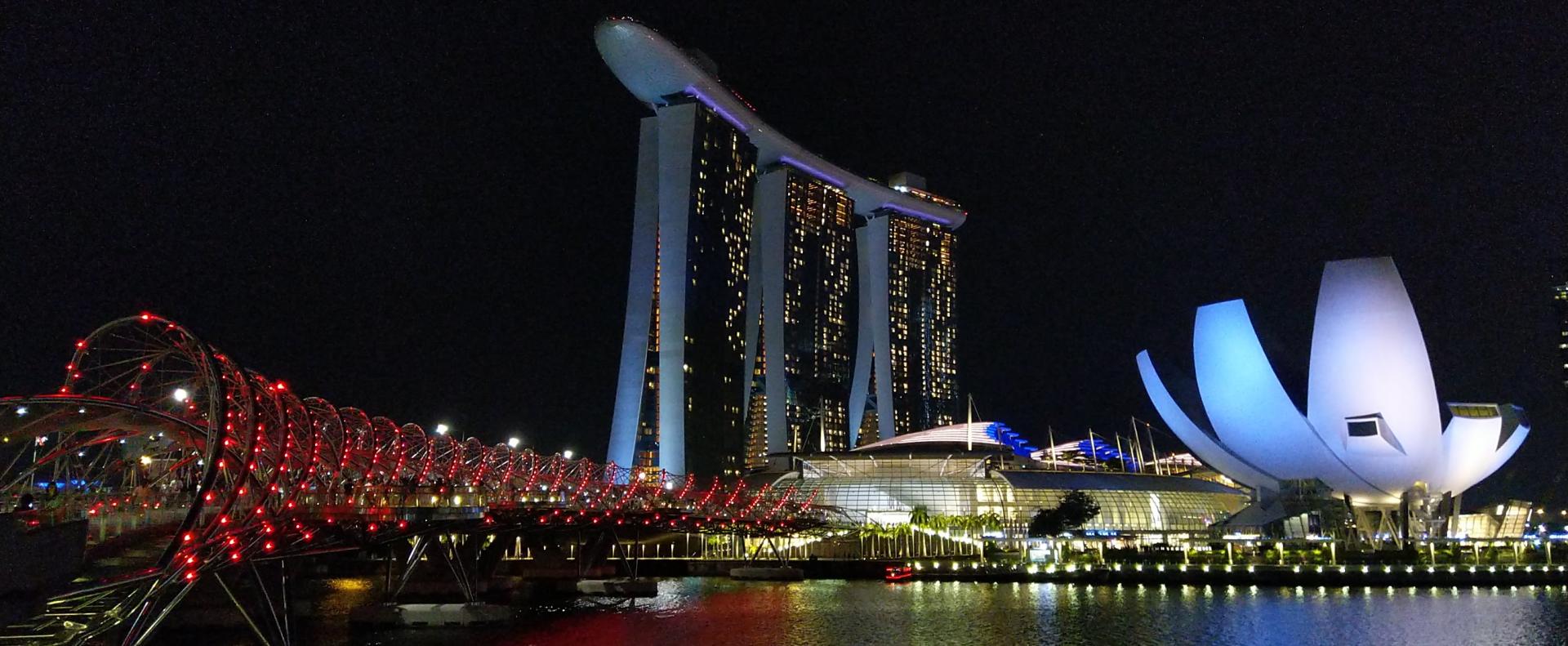 Kuvassa Singaporen tunnetuin maamerkki: Marina Bay Sand-hotelli ja Singaporen dna:ksi kutsuttu silta. Kuvassa oikealla lotuksen kukan muotoinen nykytaiteen museo.