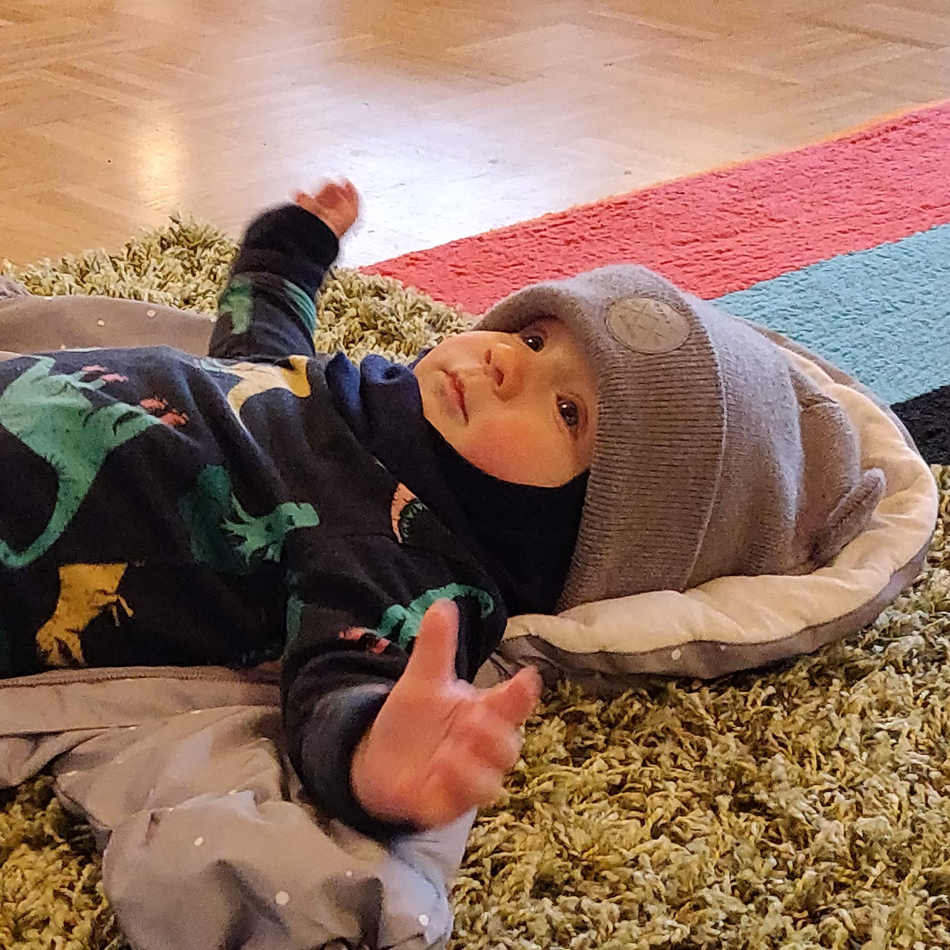 Vauva puettuna lattialla valmiina lähtöön perhekerhosta