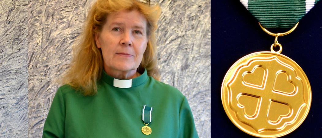 Diakoni Ulla-Maija Tuura virkapuvussaan, kultainen Pro diaconia -ansiomitali rinnassaan.