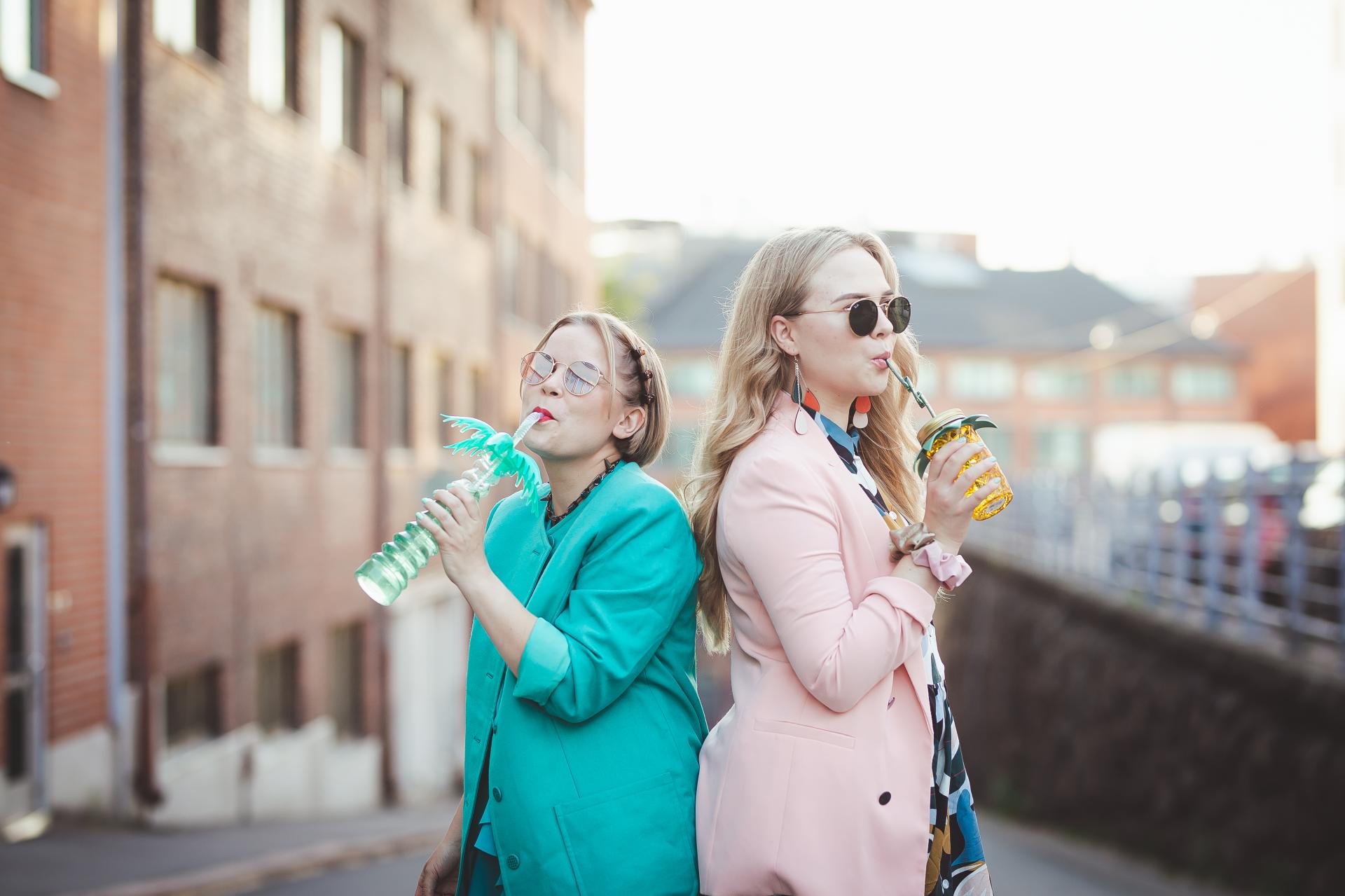 Darravapaan Katri ja Laura juovat värikkäistä muovimukeista.