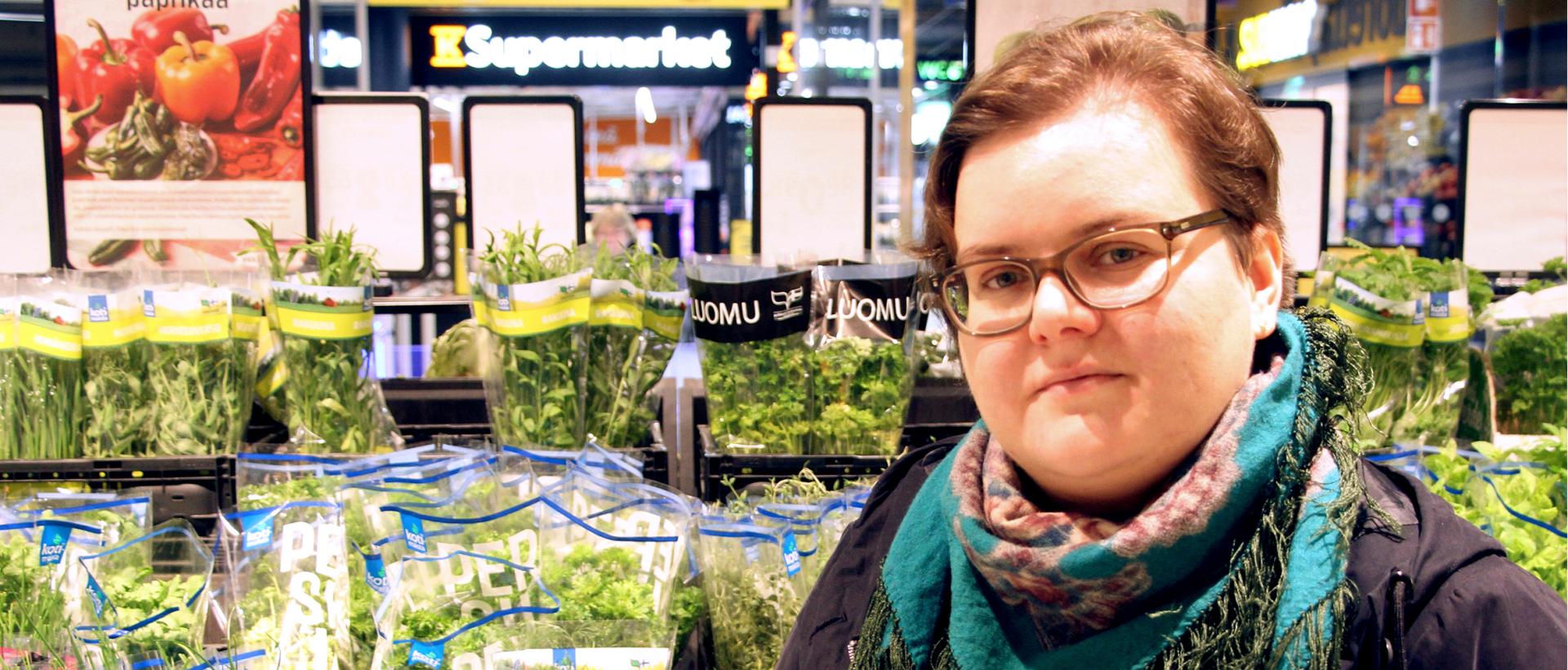 Helsinki-avun vapaaehtoinen Aino Jääskeläinen ruokakaupassa salaattihyllyn edessä