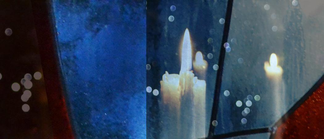 Osa Kannelmäen kirkon Elämänpuu-nimistä lasimaalausta ja himmeänä loistavia kynttilöitä.