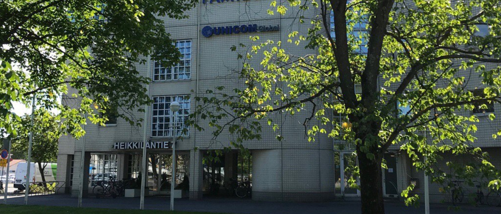 Heikkiläntien toimistorakennus, puita edessä.