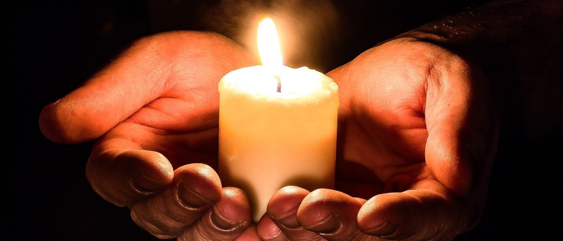 kynttilä käsissä